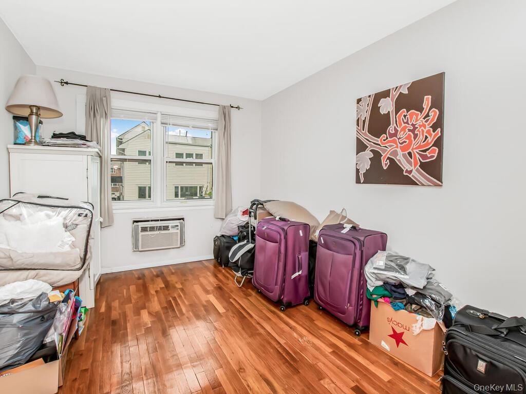 Apt 2 - Rec room with a wall mounted AC and hardwood / wood-style flooring