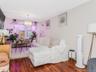 Apt 1 - Living area featuring a chandelier, wood finished floors, and a wall unit AC