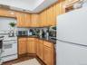 Apt 1 - Kitchen featuring white appliances, tasteful backsplash, dark wood-style flooring, and dark stone counters