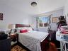 This room features hardwood flooring, a ceiling-mounted light fixture, and a window with patterned curtains