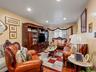 Living area featuring recessed lighting, light-colored walls, and hardwood flooring visible beneath a patterned rug