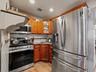 The kitchen features stainless steel appliances, including a refrigerator, microwave, and range