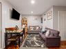 The living area features hardwood floors, light gray walls, and recessed lighting