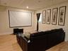 Home theater featuring a drop ceiling,  Pergo like finished floors, dry bar, and recessed lighting