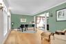 living room featuring ornate columns, wood finished floors, and crown molding