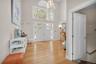 Foyer with a high ceiling, plenty of natural light, light oak wood finished floors, a chandelier, and stairway