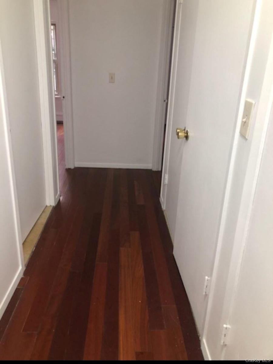 Hallway with dark hardwood / wood-style floors