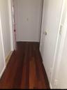 Hallway with dark hardwood / wood-style floors