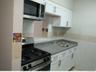 Kitchen with white cabinets, stainless steel appliances, and tile walls