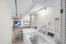Dedicated laundry area featuring a washer and dryer, convenient shelving, and a hanging rack
