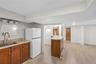This expansive space features light wood-look flooring, a wet bar with a curved countertop.