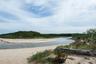 Tranquil coastal inlet with sandy shoreline and natural dune landscape, showcasing the area's unspoiled waterfront beauty and serene surroundings