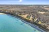 Elevated aerial showcasing a dramatic waterfront land parcel along the bluff, with expansive shoreline views, neighboring properties, and miles of sce