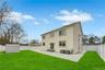 Rear view of property featuring a storage unit, a patio area, a lawn, and a fenced backyard