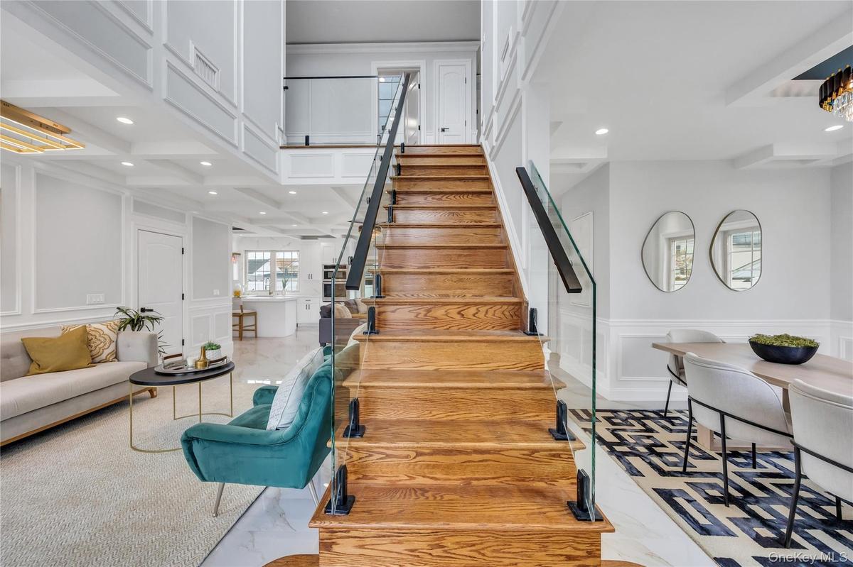 Stairway featuring wainscoting, a decorative wall, and recessed lighting