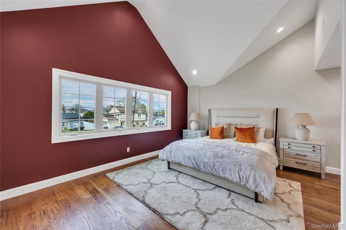 Bedroom featuring recessed lighting, high vaulted ceiling, wood finished floors, and baseboards