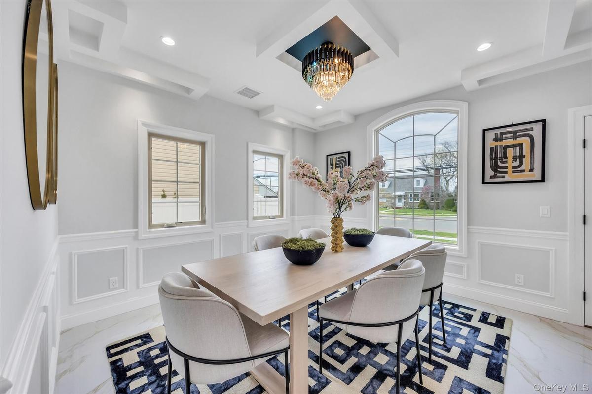 Dining space featuring marble finish floor, a decorative wall, a wainscoted wall, and recessed lighting