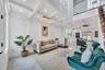 Living room featuring beam ceiling, recessed lighting, coffered ceiling, marble finish floor, and a decorative wall