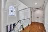 Hall with visible vents, an inviting chandelier, a healthy amount of sunlight, and a decorative wall