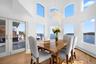 This inviting dining area features hardwood floors, a beautiful chandelier, and a prominent dining table