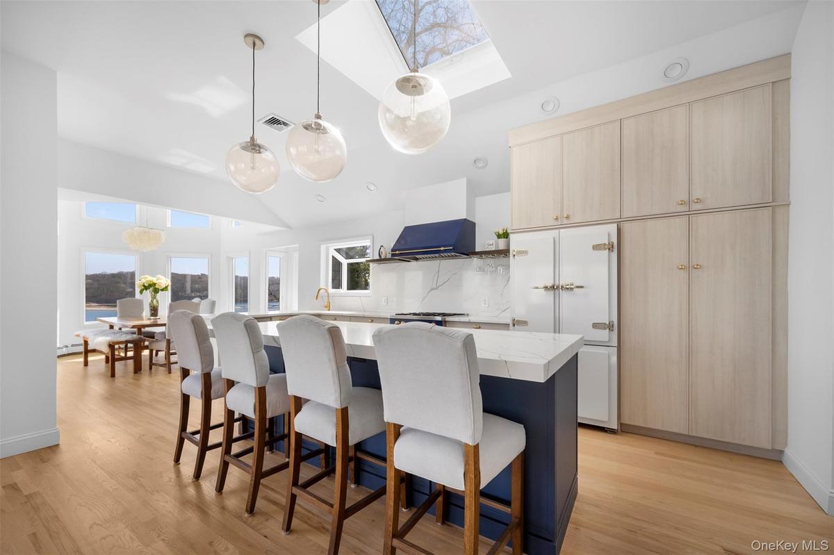 The property features an open-concept kitchen with a large center island, pendant lighting, and light-toned wooden flooring