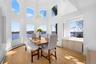 This dining area features extensive windows, including arched windows, offering abundant natural light and views of the water