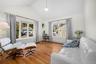 This bright room features hardwood floors, a vaulted ceiling, and ample natural light from multiple windows