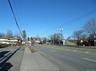 View of asphalt street with sidewalks, curbs, and street lighting