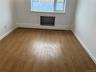 Spare room featuring a baseboard radiator, wood finished floors, and baseboards