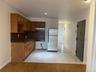 Kitchen with freestanding refrigerator, under cabinet range hood, a sink, tasteful backsplash, and baseboards