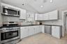 Spotless Kitchen with nice white cabinetry, stainless steel applicances and access to the side yard.
