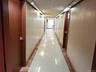 Corridor featuring light tile patterned flooring, a paneled ceiling, and inlaid floor details