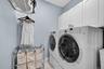 Washroom with washer and dryer, cabinet space, and light tile patterned flooring