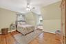 Bedroom with baseboard heating, light wood-style floors, a ceiling fan, and lofted ceiling