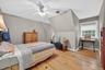 Bedroom featuring baseboard heating, wood finished floors, and a ceiling fan