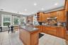 Kitchen with under cabinet range hood, stainless steel gas cooktop, ceiling fan, light tile patterned flooring, and recessed lighting