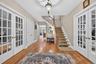 Foyer with french doors, wood finished floors, and stairway