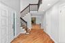 Entrance foyer with light wood-style flooring, baseboards, recessed lighting, stairway, and a stone fireplace