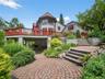 Rear view of house featuring a wooden deck and a patio area