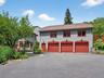 View of front of house featuring asphalt driveway, an attached garage, and roof with shingles
