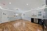 Two tone kitchen featuring dual tone cabinets, dishwasher, light wood-type flooring, ornamental molding, and fridge