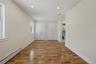 Unfurnished bedroom featuring baseboard heating, multiple closets, light wood-style flooring, recessed lighting, and ensuite bath