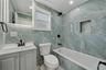 Bathroom featuring ornamental molding, vanity, tile walls, a combined bath / shower with marble appearance, and recessed lighting