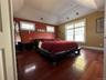 Primary bedroom with a raised ceiling and Brazilian Red Mahogony wide plank wood flooring