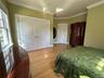 Bedroom featuring light Bamboo finished floors, ornamental molding, and an oversized closet