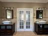 Full bath with Italian porcelain tile, two marble topped vanities, French doors, and radiant heat flooring