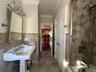 Full bath with tile walls, crown molding, a wainscoted wall, and bathing tub / shower combination
