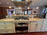 Kitchen featuring range hood, pendant lighting, recessed lighting, light granite counters, and stainless steel appliances