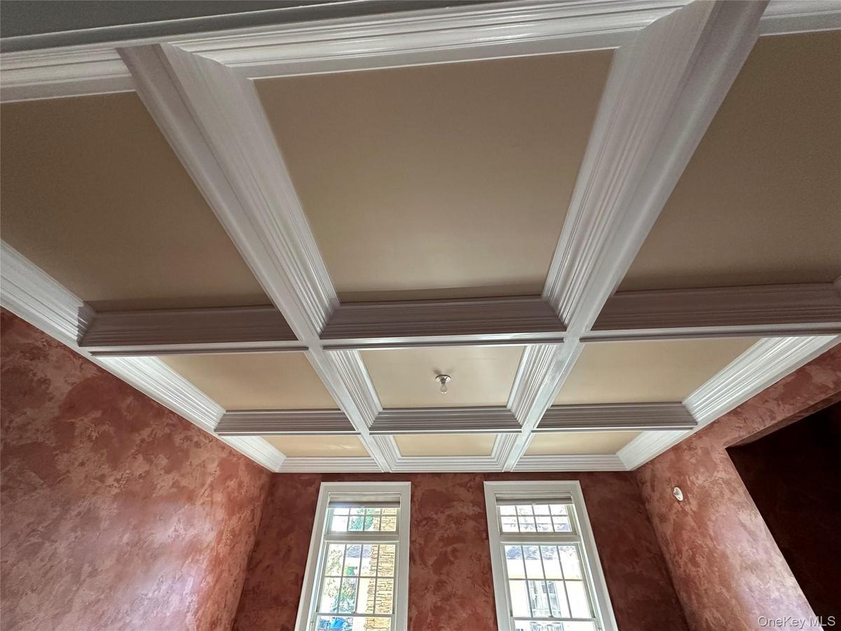 Detailed view of beamed ceiling, ornamental molding, and coffered ceiling