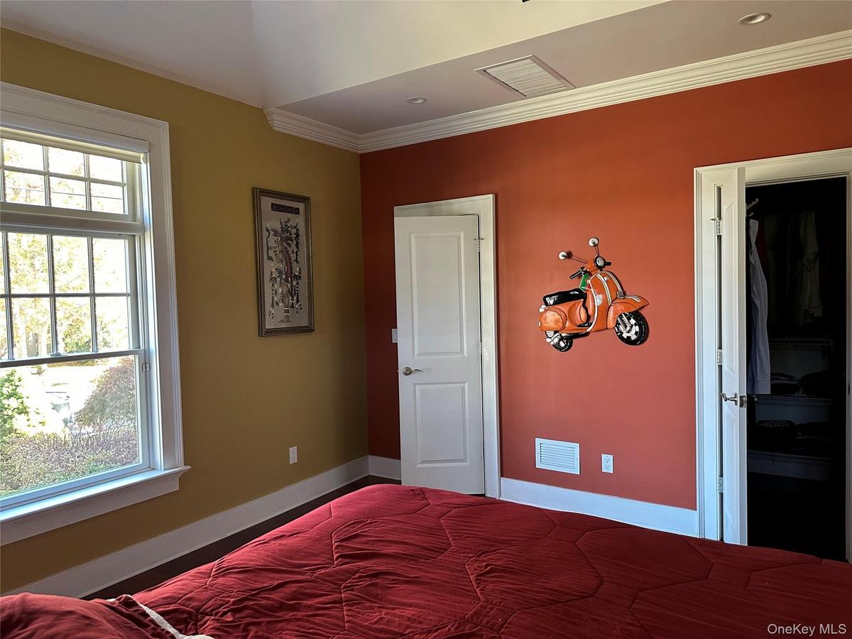 Primary bedroom with base and crown molding.  @ generous sized California style walk in closets